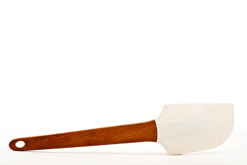 Pastry scraping spatula, rubber or silicone scraping spatula with wooden handle for confectionery isolated on white background with space for text