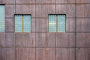 Rustic brown wall and glass block windows in a square pattern, as an abstract background
