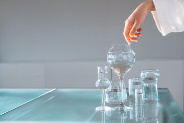 Female Hand Touching Glass Transparent Glasses, Snifters On Table. Water Balance Concept. Text Space. Taking care