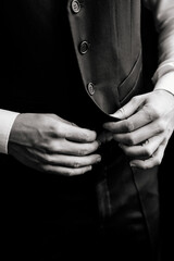 Close-up men's hands fasten the buttons. The groom in a suit, shirt. stylish classic menswear.