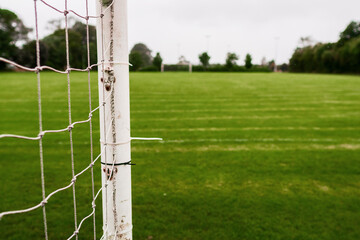 White metal soccer or football goal post and freshly cut training pitch. Cloudy sky. Simple sport...