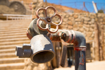 Fire safety in a country with a hot climate. Fire hydrant pipe with red valve. Protecting tourists on the beach from fire.