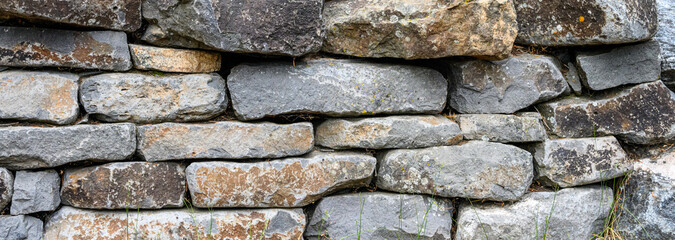 Textured, rough, stacked stone wall as a rustic natural background
