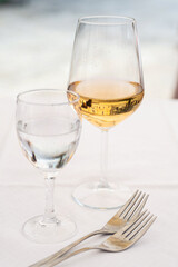 glasses of white wine on a table, shallow depth of field with focus on the wineglass