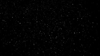 Small snowflakes falling softly from the sky from left to right and then changing their way because of the wind. Beautiful snowfall isolated on the black background.