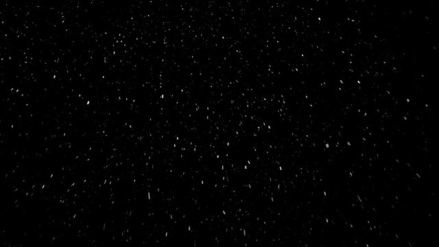 Small snowflakes falling softly from the sky from left to right and then changing their way because of the wind. Beautiful snowfall isolated on the black background. © railwayfx