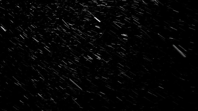 Beautiful atmospheric blizzard with small snowflakes rushing in different directions and constantly changing their way because of the wind. isolated on the black background.