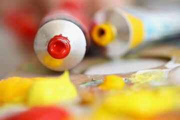 On wooden palette bright paint and tubes of paint