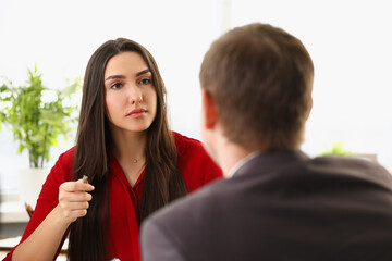 A man in a suit conducts an interview with a woman
