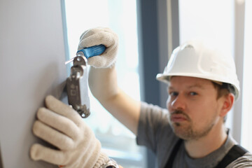 Man twists a screwdriver in a cabinet of fittings