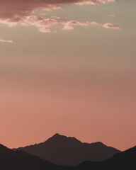 Pastel sunset over silhouetted mountains. Matte color. 