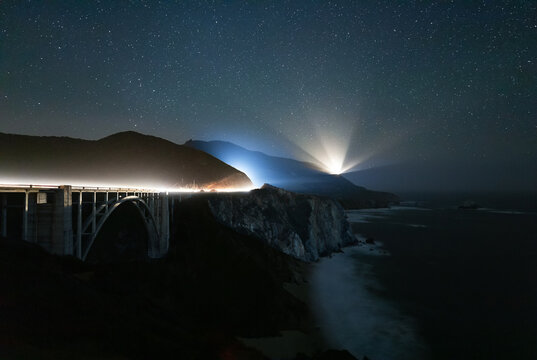 The Bixby Bridge in Carmel Highlands, California at night under the stars with traffic light trails