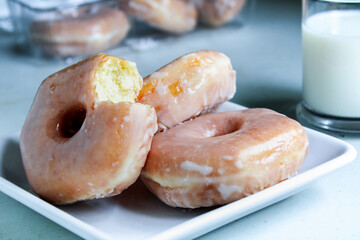 Glazed donuts on a plate and a glass of milk