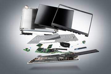 flying parts of a notebook computer. hardware components mainboard cpu processor display RAM cables and cooling fan flying out of silver laptop PC case dark gray exploded view background - obrazy, fototapety, plakaty