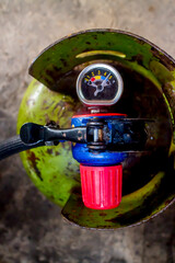 gas cylinder regulator with gauge on green gas cylinder.
