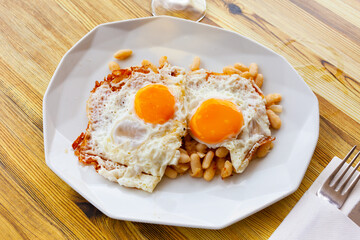 Catalan style white beans served with fried eggs. Hearty and healthy snack