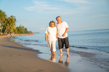 Family On Summer Beach Vacation, healthy older couple running on sea beach, Concept for .caring for the elderly, Caregiving to older persons and relations of the family to support elderly state