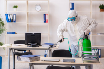 Old male contractor in office disinfection concept