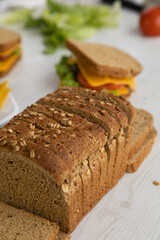 sandwiches prepared with fresh ingredients, armed with whole wheat bread, cheese, lettuce and a plate with nachos on a table next to a sliced mold, delicious food prepared at home, snack