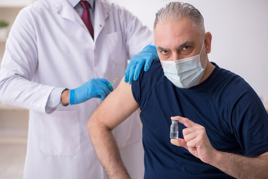 Old male patient visiting young male doctor in vaccination conce - Powered by Adobe