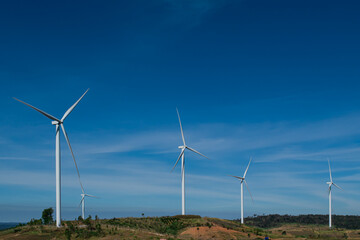 Wind turbines generating electricity over blue sky