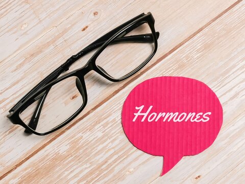 Text hormones written on bubble speech with eye glasses.