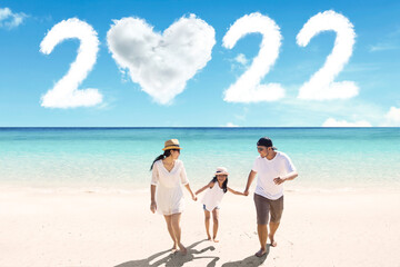 Child walk with parents on beach with 2022 numbers
