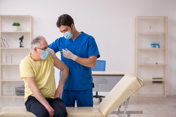 Obraz premium Old male patient visting young male doctor in vaccination concep