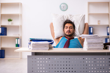 Young male employee coming to work straight from bed