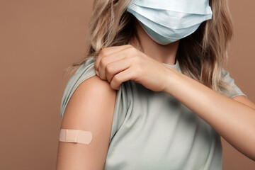 Vaccination to protect from covid-19 disease: unrecognizable woman in medical face mask show arm...