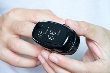 Fototapeta premium A device to measure the oxygen saturation of a person at the fingertips. And checking oxygen depletion is an emergency sign of pneumonia caused by the COVID-19 virus.
