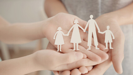 Children hands holding paper family cutout, family home, foster care, homeless charity support...