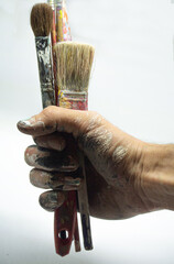 hand holding paintbrushes. in white background. vertical