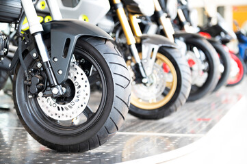 Obraz premium The front tire of a parked custom motorcycle , Front motorcycle disk breaks and tire in close up