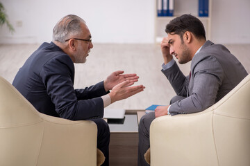 Two businessmen discussing project at workplace