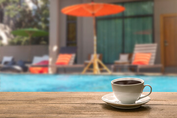 A cup of hot coffee  beside swimming pool.