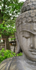 Big Buddha sculpture in natural stone in the garden