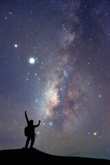 Milky Way on Night sky and silhouette man on the mountain, Success or winner, leader concept. High iso with Noise.