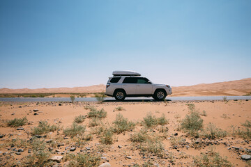 Inner Mongolia ,China - Circa 2021:  Driving White 2020 Toyota 4Runner TRD crossing in the desert...