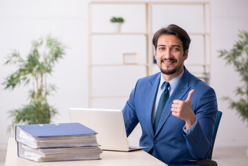 Young male employee and too much work in the office