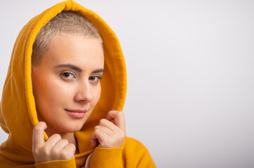 Young woman in an ocher hood on a white background.