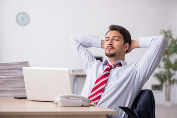 Young male employee sitting at workplace