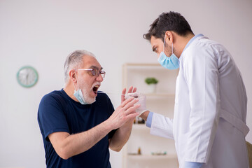 Old male patient visiting young male doctor otorhinolaryngologis