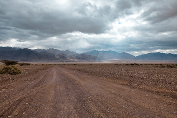 Fototapeta na wymiar Gravel road in the desert of the Negev