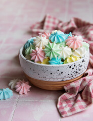 Fototapeta na wymiar Small colorful meringues in the ceramic bowl
