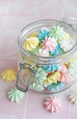 Small colorful meringues in the glass jar