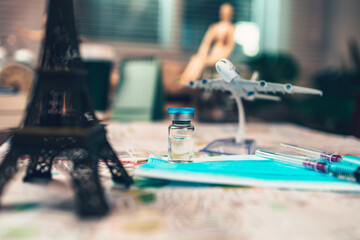 Vaccine, syringe and mask on map. Important equipment before traveling during COVID concept.