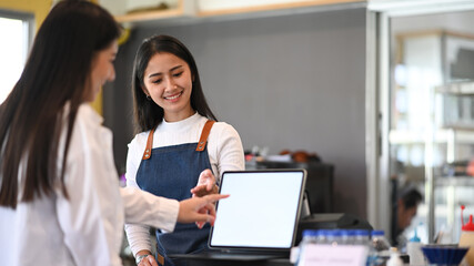 Friendly female waitress recommending  menu to her customers.