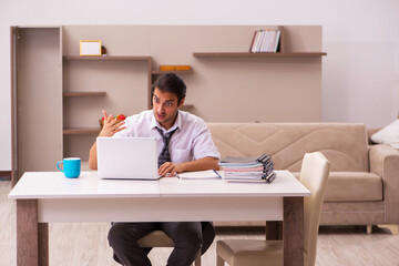 Young male employee working from home during pandemic
