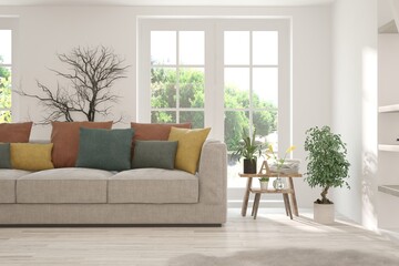 White living room with sofa and summer landscape in window. Scandinavian interior design. 3D illustration
